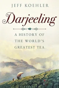 A book cover titled "Darjeeling: A History of the World's Greatest Tea" by Jeff Koehler. The cover features a scenic illustration of a tea plantation in the Himalayan mountains, with a woman in a traditional umbrella standing on a hill overlooking the landscape.